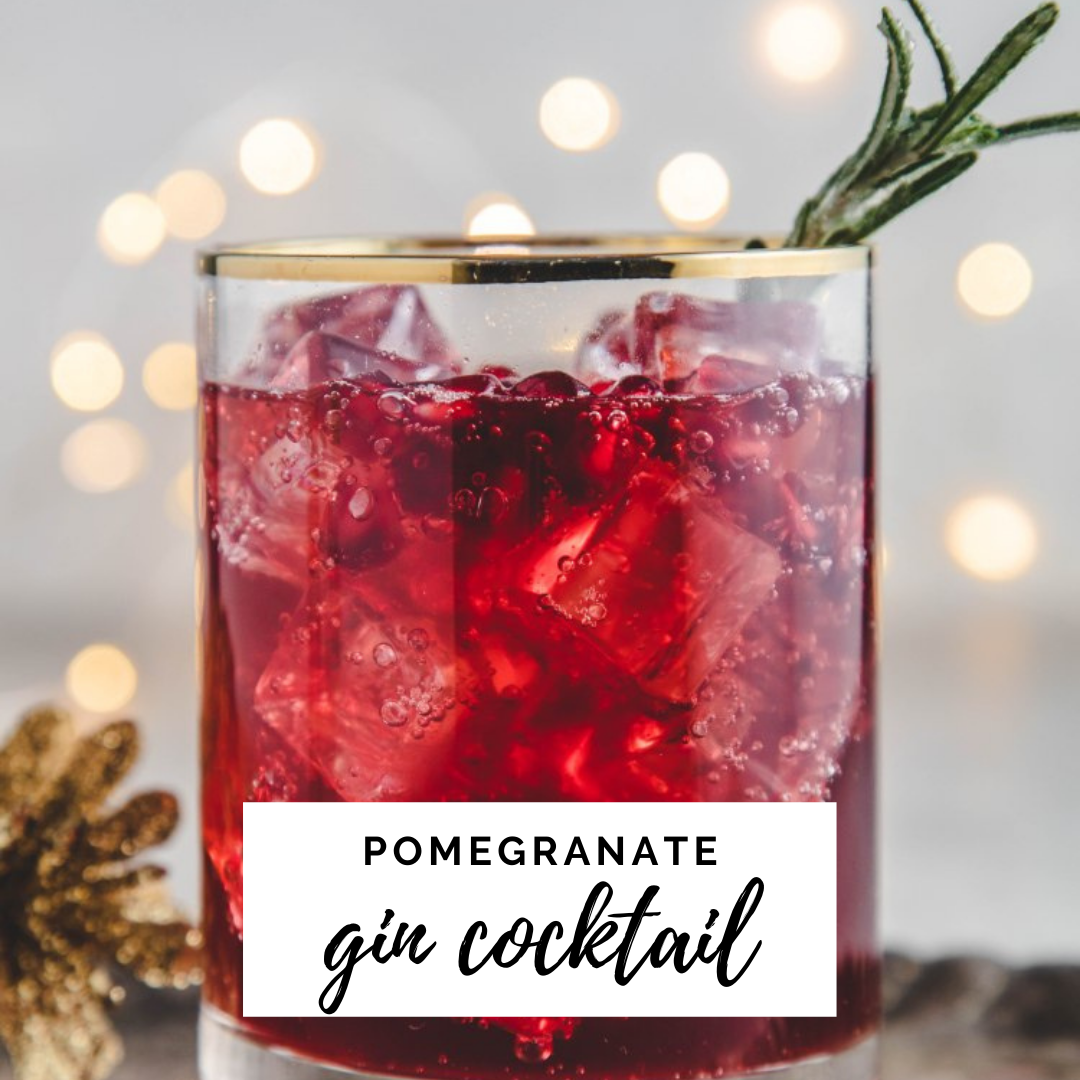 pomegranate gin cocktail in a gold rimmed glass garnished with rosemary