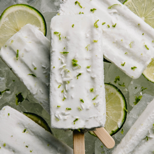 Overhead view of a stack of margarita popsicles. Popsicles are sprinkled with lime and coconut.