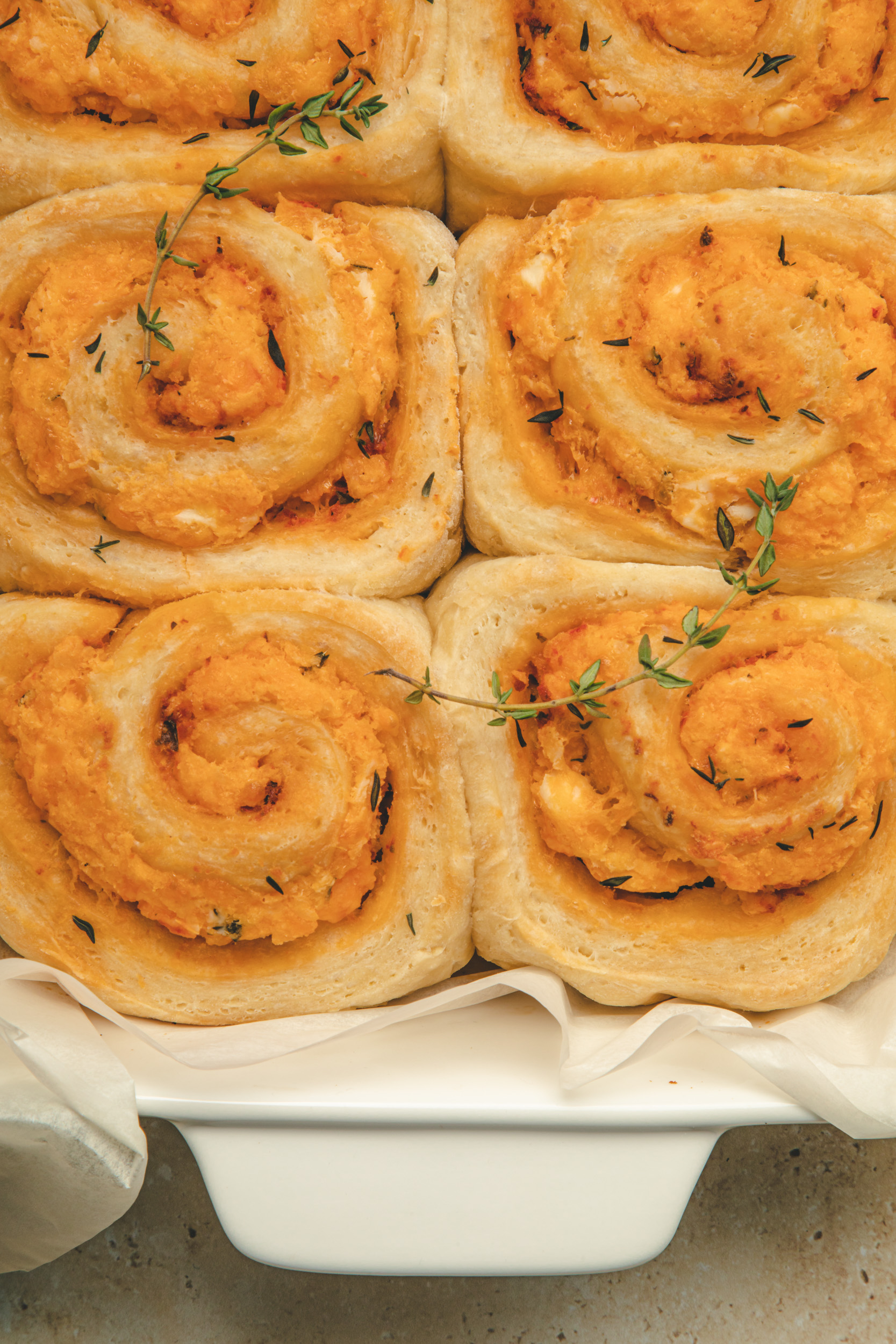 Overhead, close up view of Turkey Cheddar Swirl Buns garnished with thyme.
