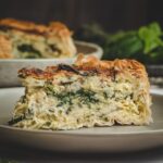 Slice of Mediterranean Vegetable Quiche in a beige plate.